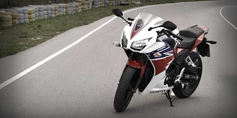 Honda CBR 300R σε λευκό, κόκκινο και μπλε χρώμα, σταματημένη σε πίστα