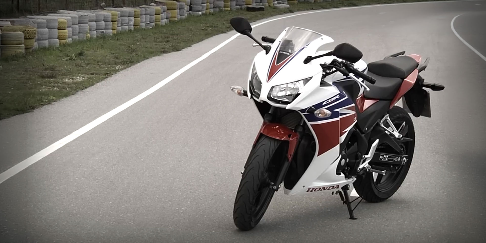 Honda CBR 300R σε λευκό, κόκκινο και μπλε χρώμα, σταματημένη σε πίστα