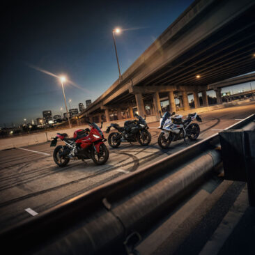 Τρεις μοτοσυκλέτες BMW F 450 RR σε διαφορετικά χρώματα σταθμευμένες κάτω από ανισόπεδη γέφυρα τη νύχτα.
