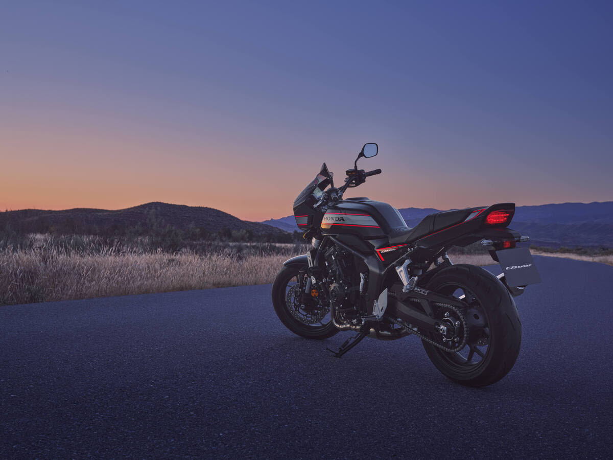 Honda CB1000F σε σκούρο χρώμα με κόκκινες ρίγες και μάσκα φαναριού, σταθμευμένη στο ηλιοβασίλεμα